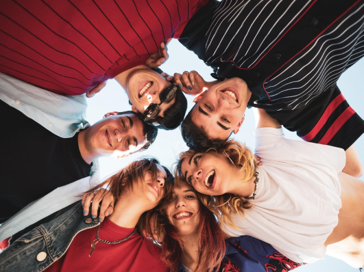 six youth in a circle with their arms around each other